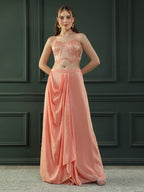 Peach drape skirt paired with brocade corset with a hand-embellished pearl highlight and plain dupatta with latkans drop on its sides.