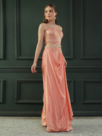 Peach drape skirt paired with brocade corset with a hand-embellished pearl highlight and plain dupatta with latkans drop on its sides.