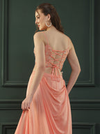 Peach drape skirt paired with brocade corset with a hand-embellished pearl highlight and plain dupatta with latkans drop on its sides.