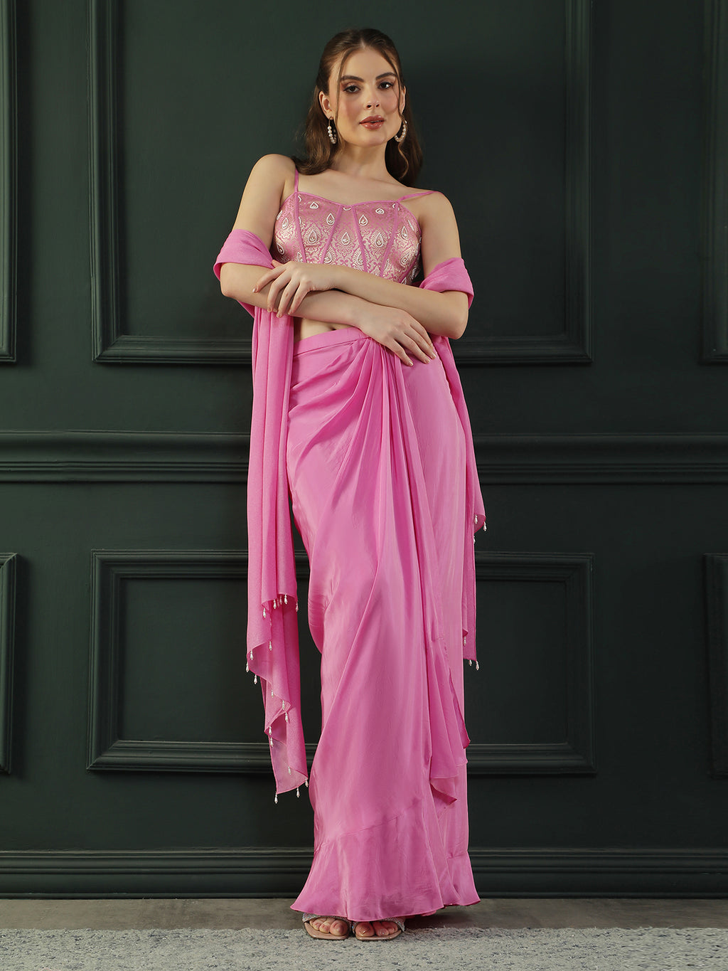 Fuscia Pink crepe drape skirt paired with brocade corset with a hand-embellished pearl highlight and plain dupatta with latkans drop on its sides.