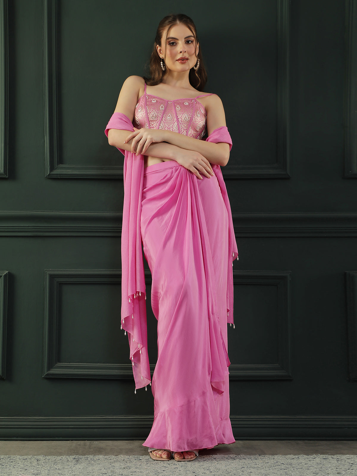 Fuscia Pink crepe drape skirt paired with brocade corset with a hand-embellished pearl highlight and plain dupatta with latkans drop on its sides.