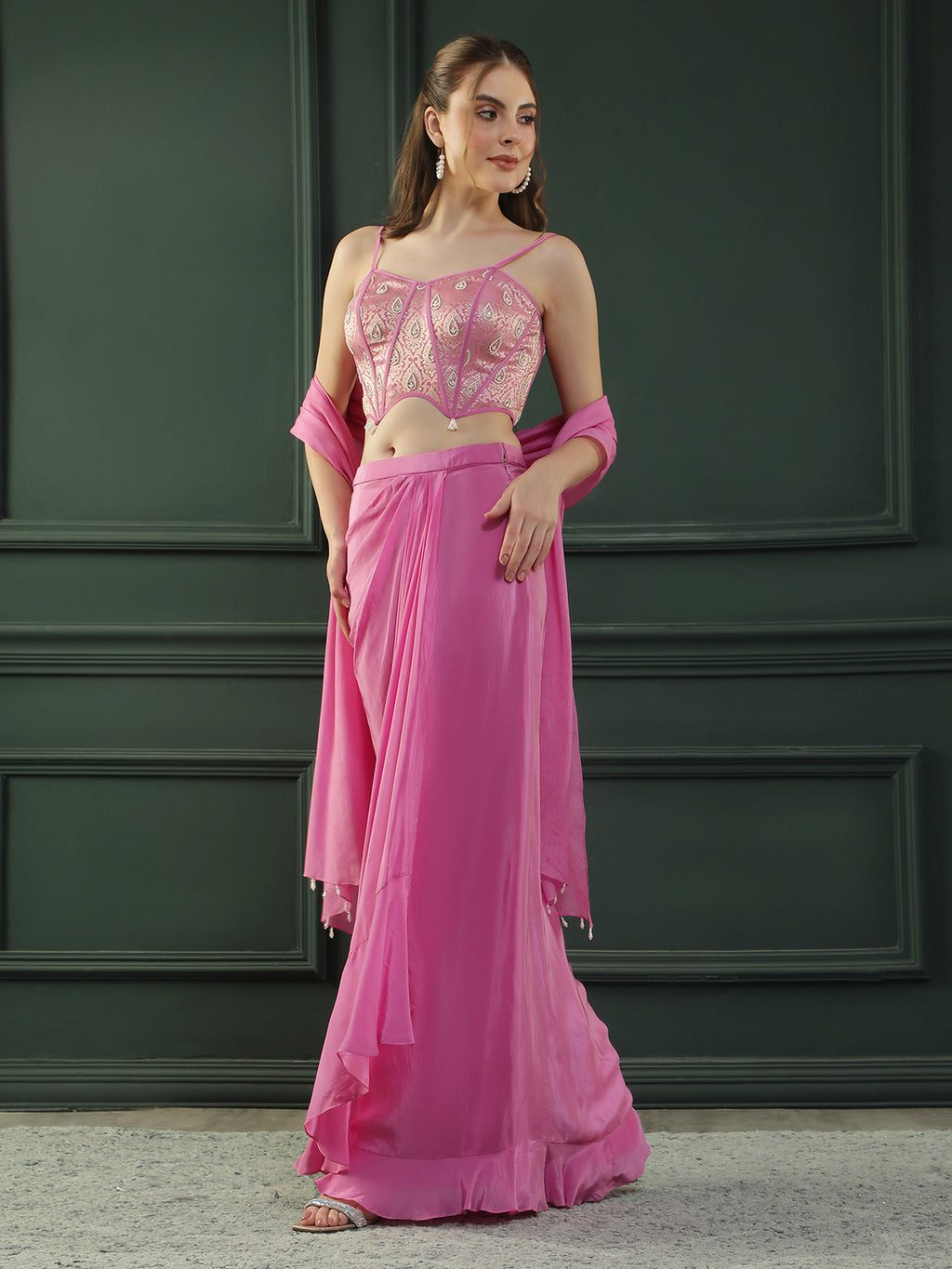 Fuscia Pink crepe drape skirt paired with brocade corset with a hand-embellished pearl highlight and plain dupatta with latkans drop on its sides.