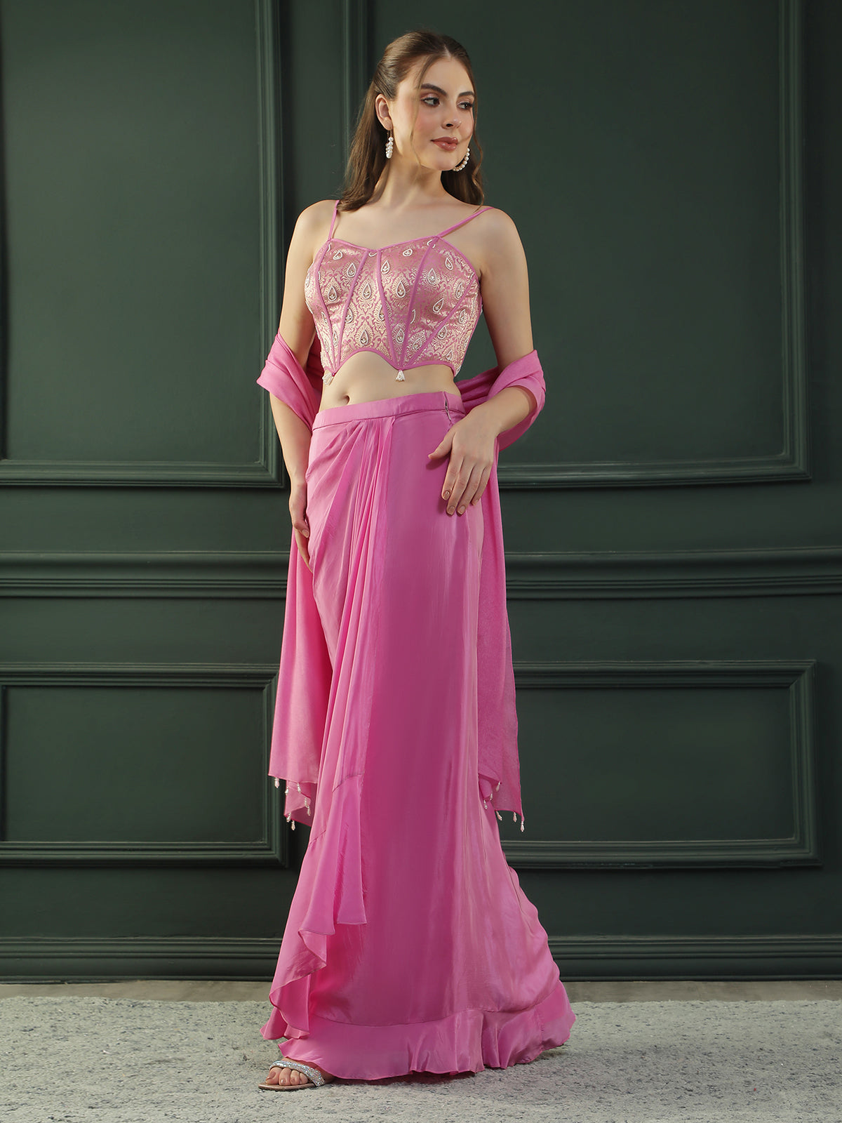 Fuscia Pink crepe drape skirt paired with brocade corset with a hand-embellished pearl highlight and plain dupatta with latkans drop on its sides.