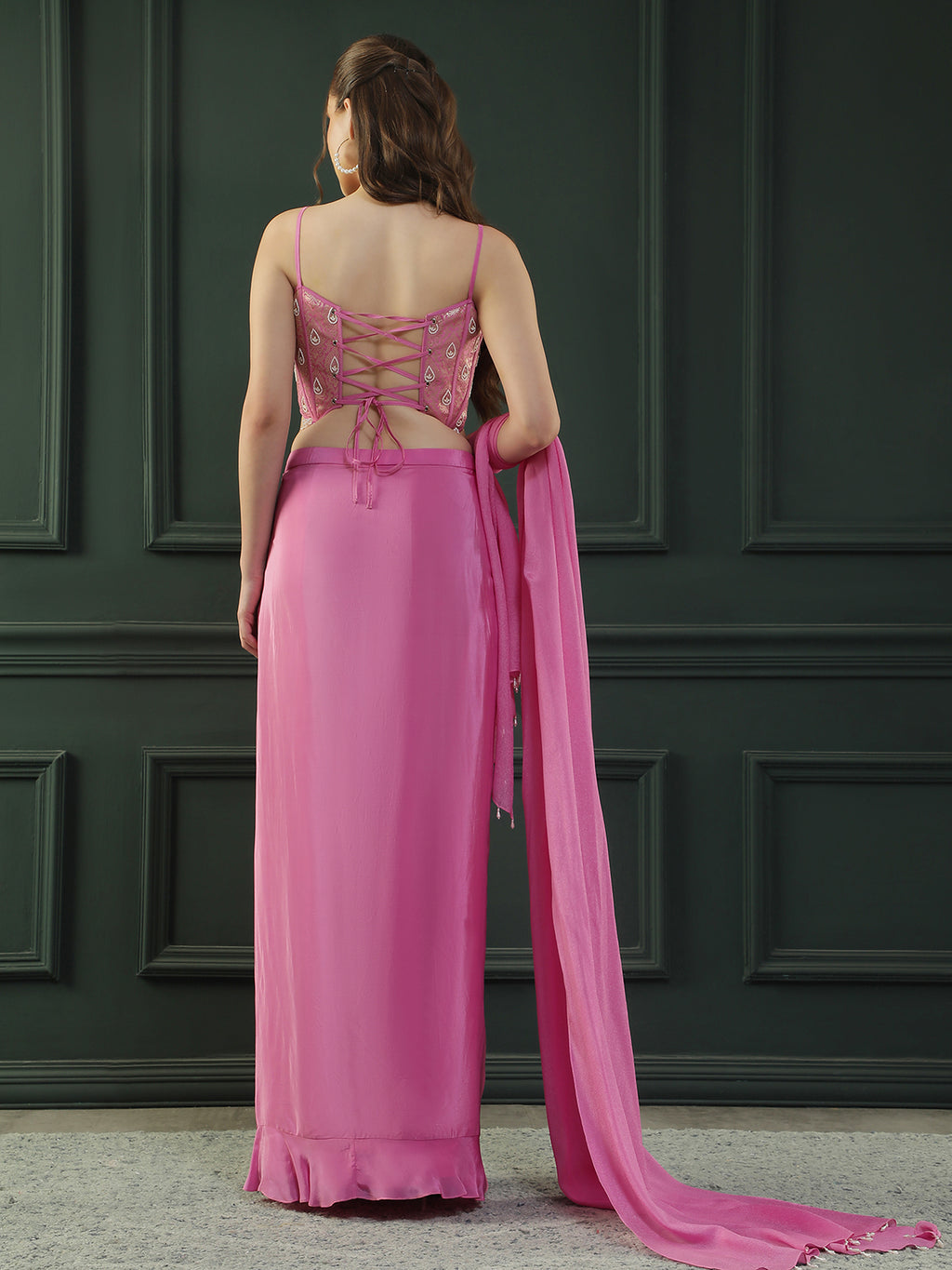 Fuscia Pink crepe drape skirt paired with brocade corset with a hand-embellished pearl highlight and plain dupatta with latkans drop on its sides.
