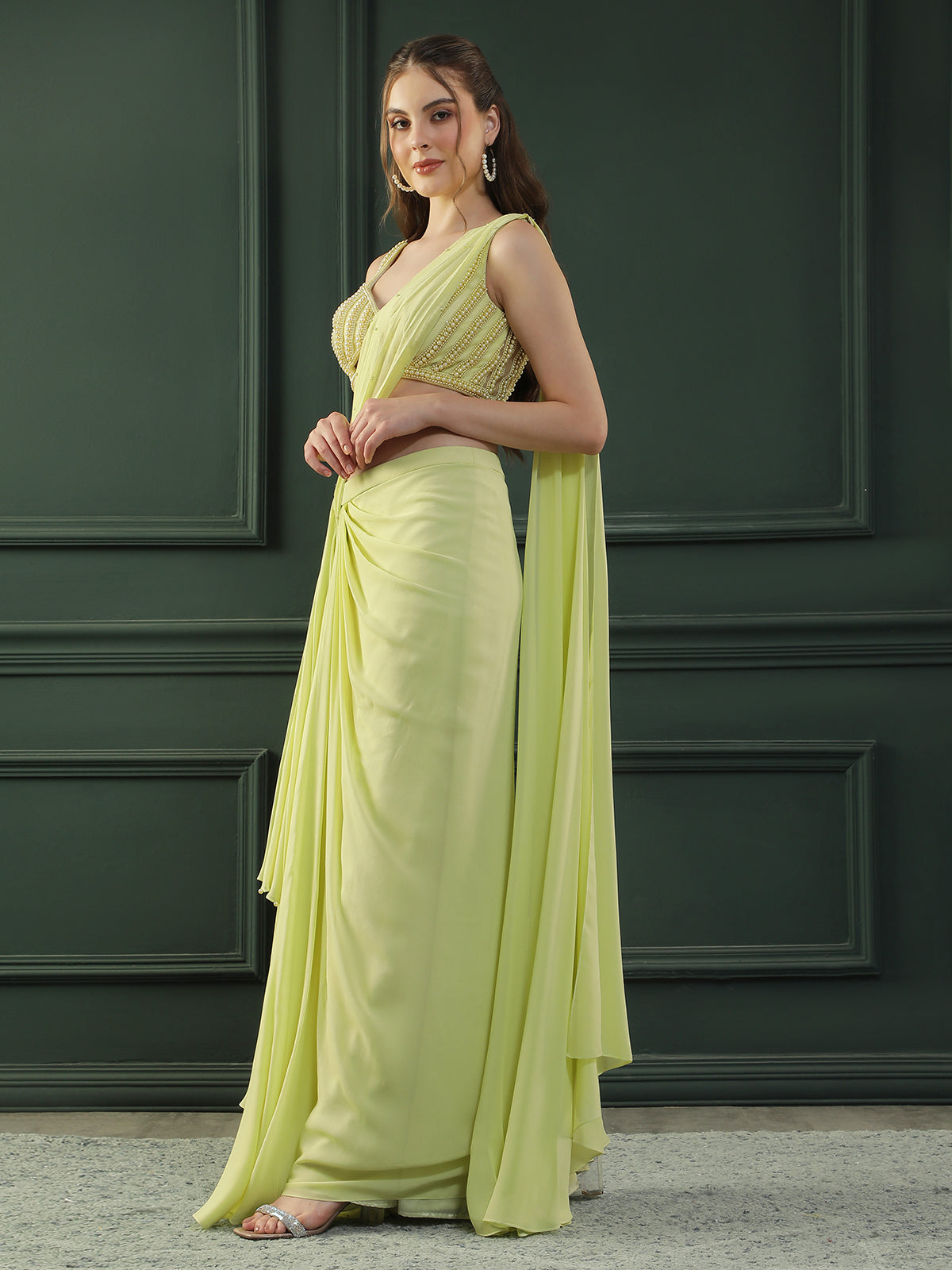 Lime-green pre-drape georgette saree paired beautifully with a hand-embellished pearl blouse.