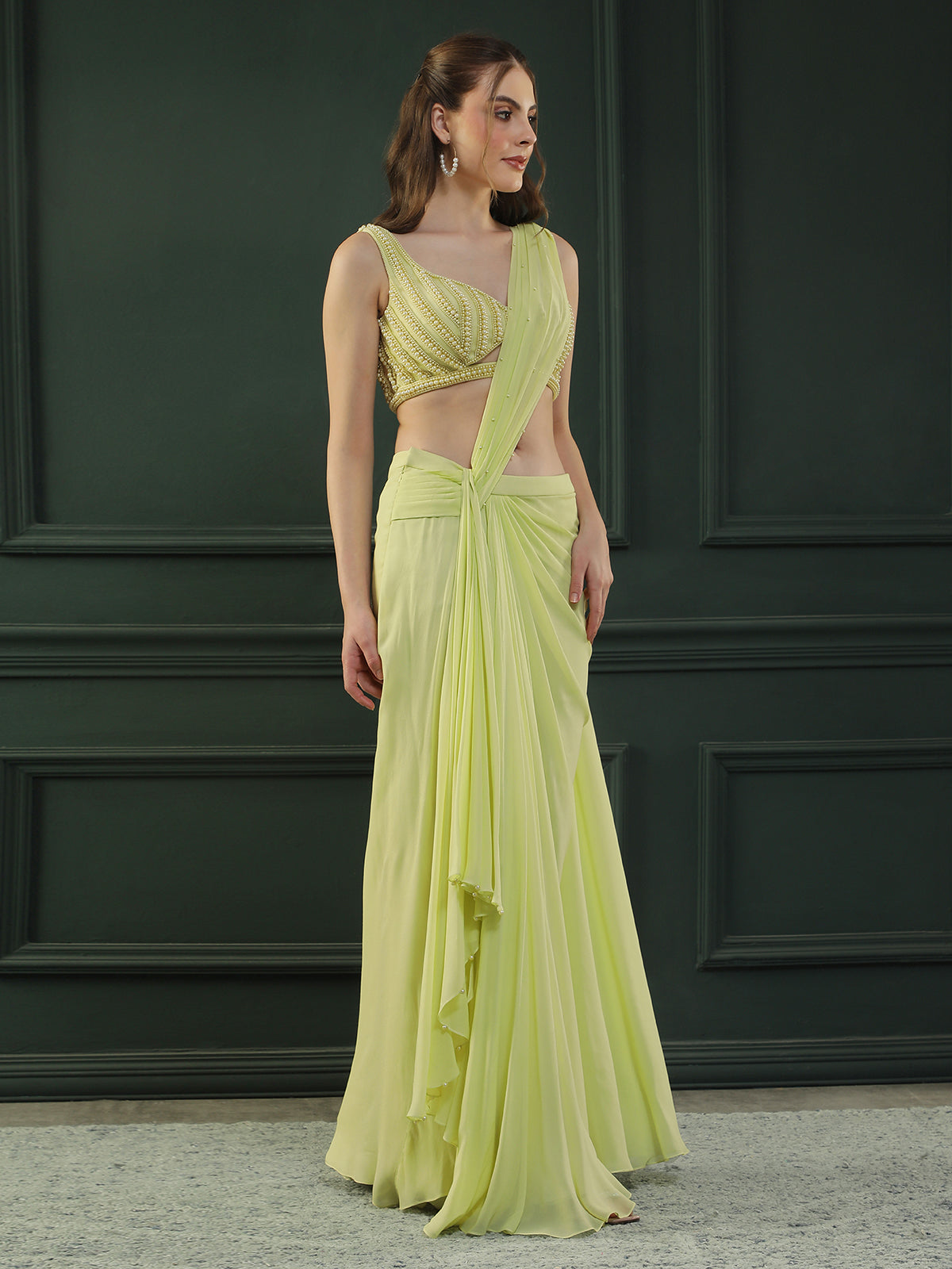 Lime-green pre-drape georgette saree paired beautifully with a hand-embellished pearl blouse.