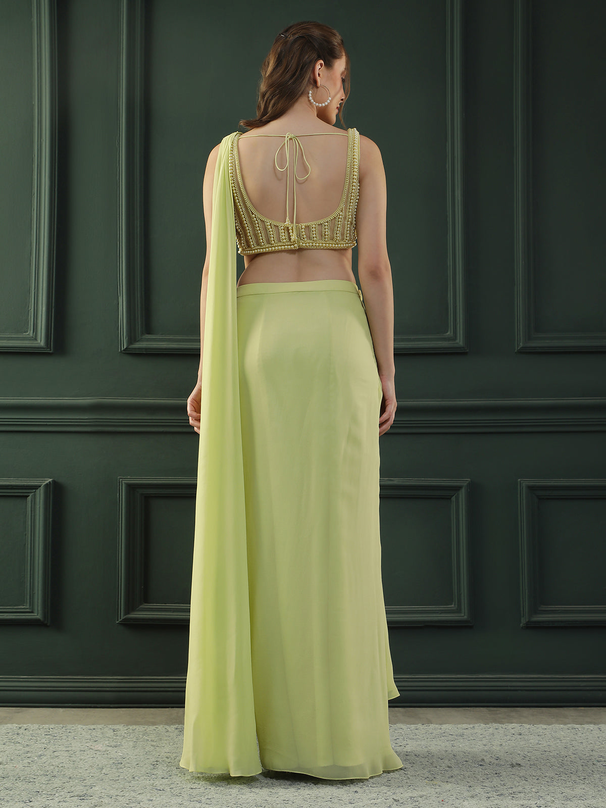 Lime-green pre-drape georgette saree paired beautifully with a hand-embellished pearl blouse.
