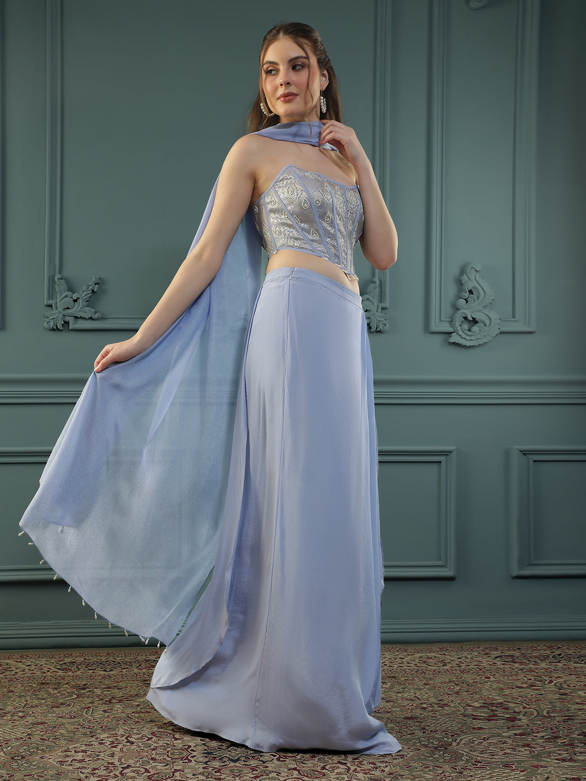 Lilac drape skirt paired with brocade corset with a hand-embellished pearl highlight and plain dupatta with latkans drop on its sides.