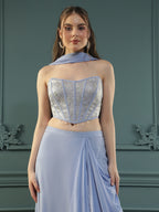 Lilac drape skirt paired with brocade corset with a hand-embellished pearl highlight and plain dupatta with latkans drop on its sides.