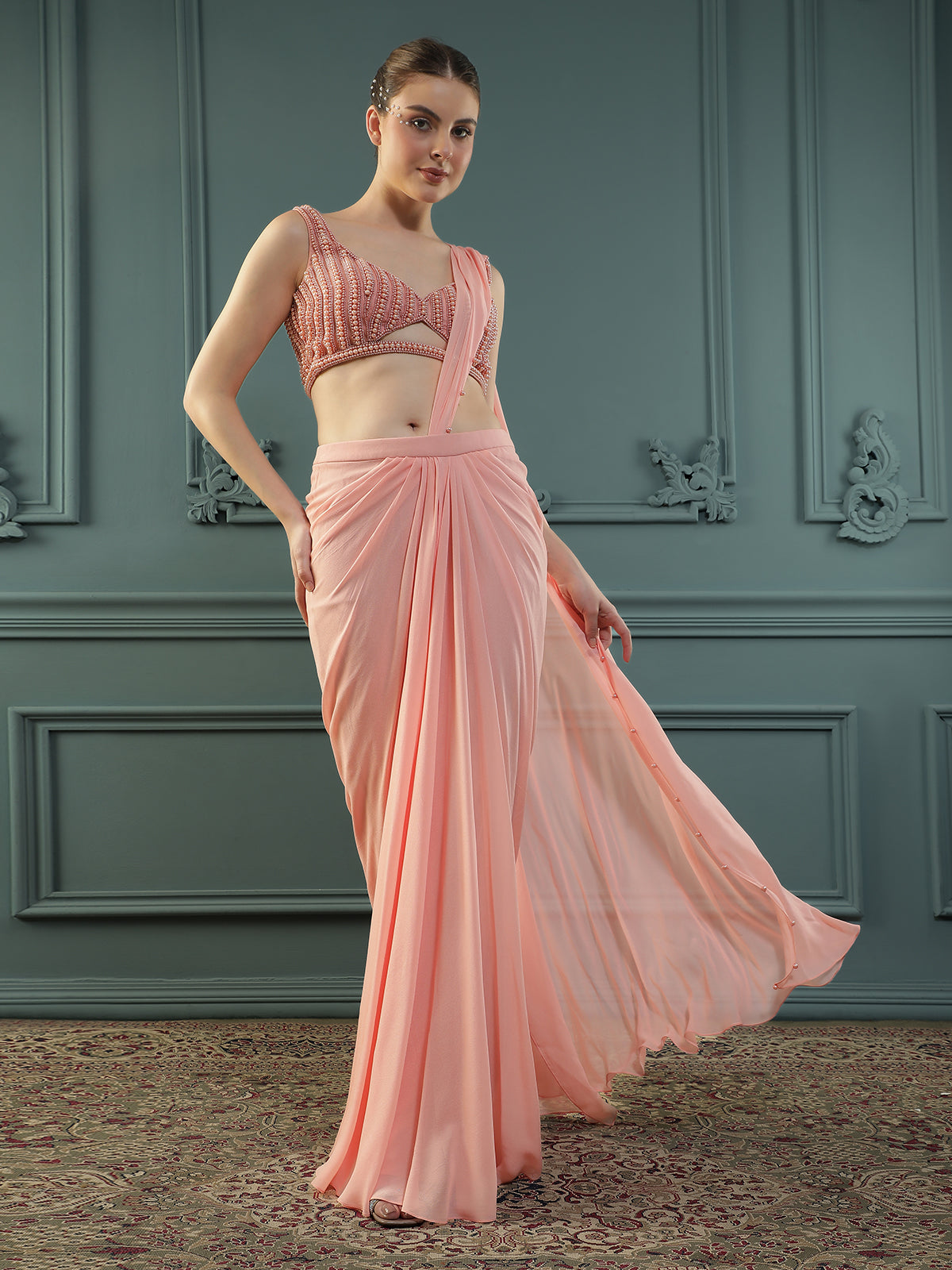 Peach pre-drape georgette saree paired beautifully with a hand-embellished pearl blouse.