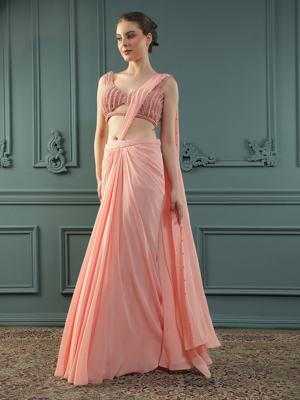 Peach pre-drape georgette saree paired beautifully with a hand-embellished pearl blouse.