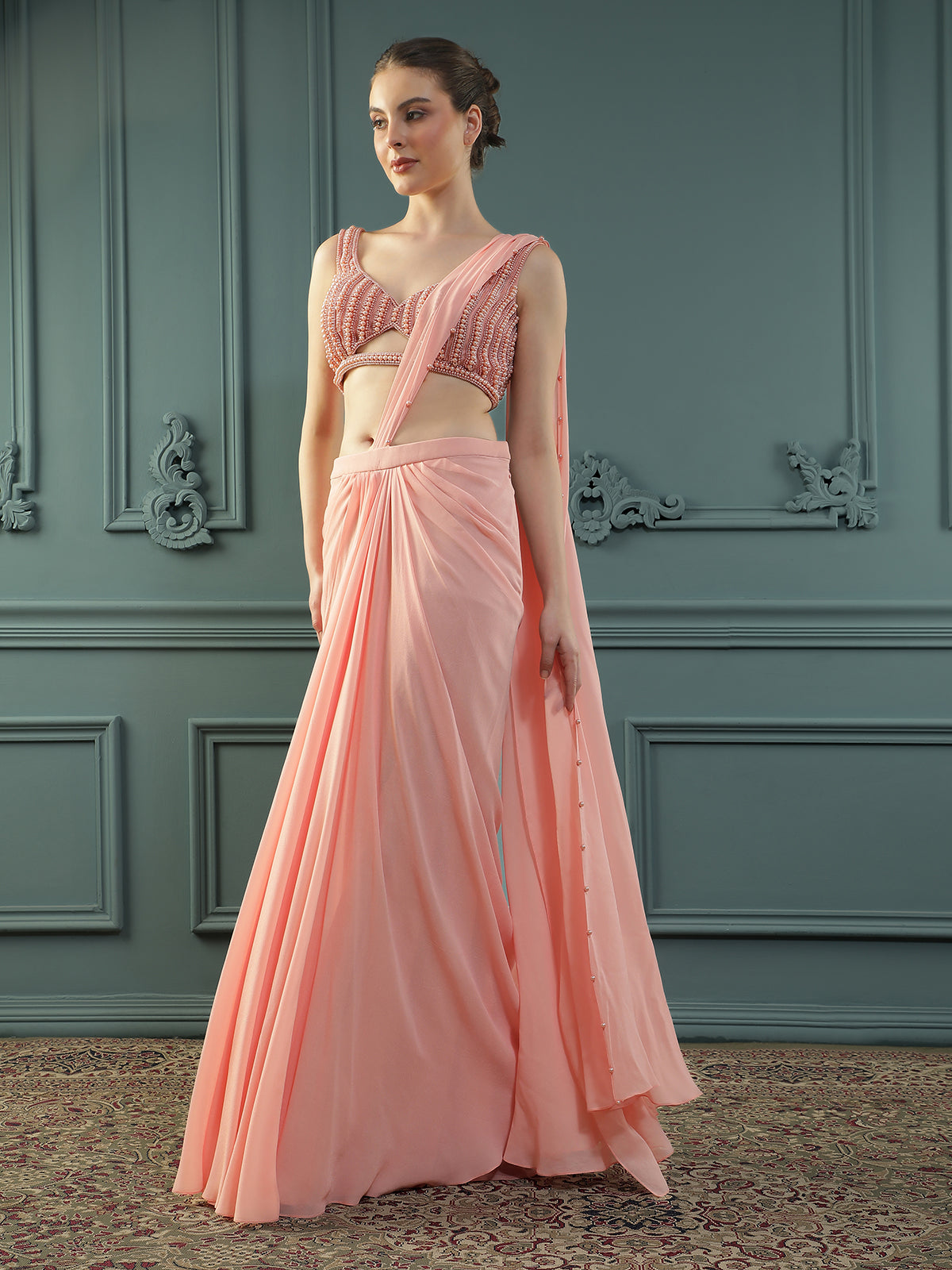 Peach pre-drape georgette saree paired beautifully with a hand-embellished pearl blouse.