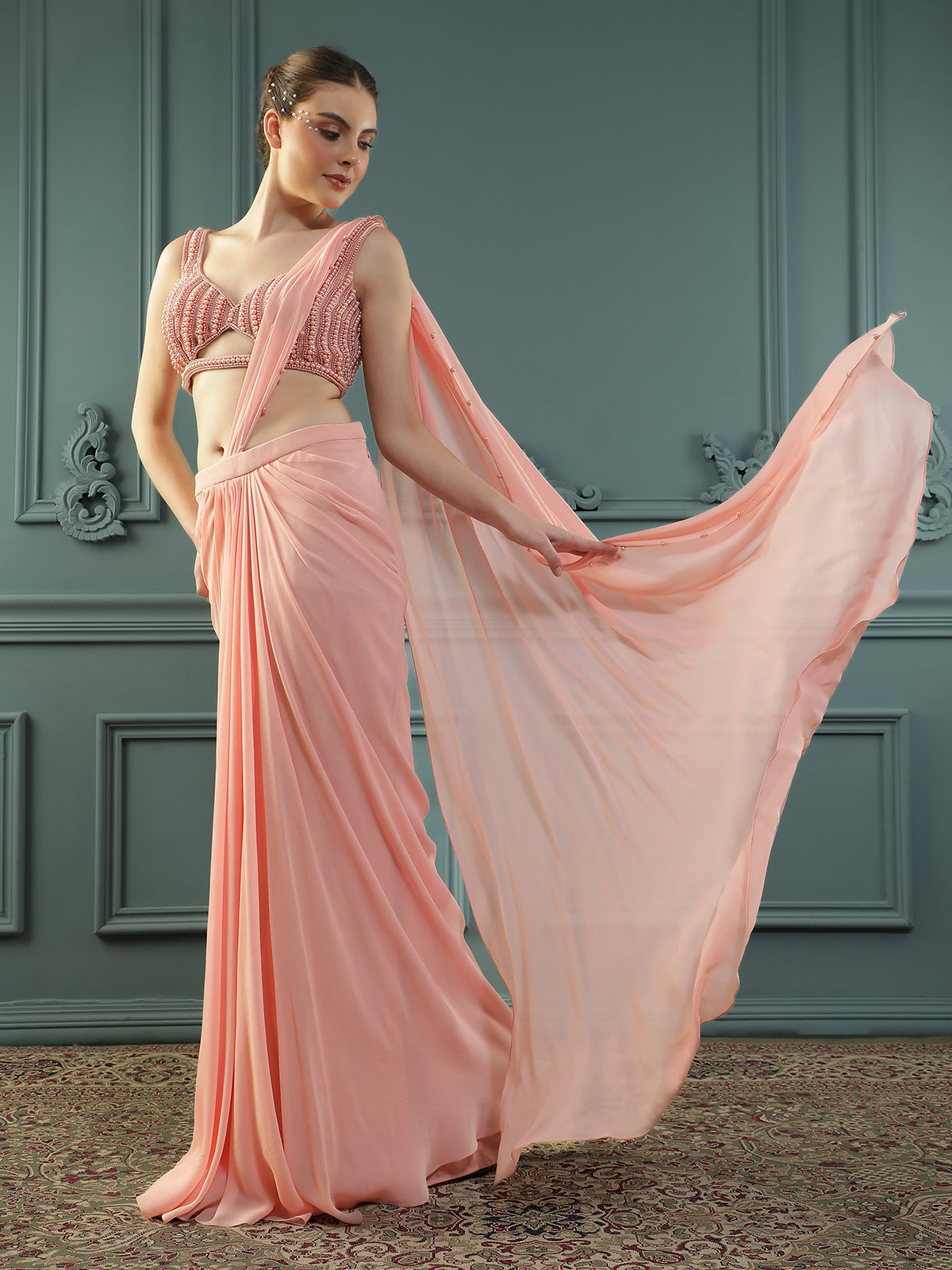 Peach pre-drape georgette saree paired beautifully with a hand-embellished pearl blouse.