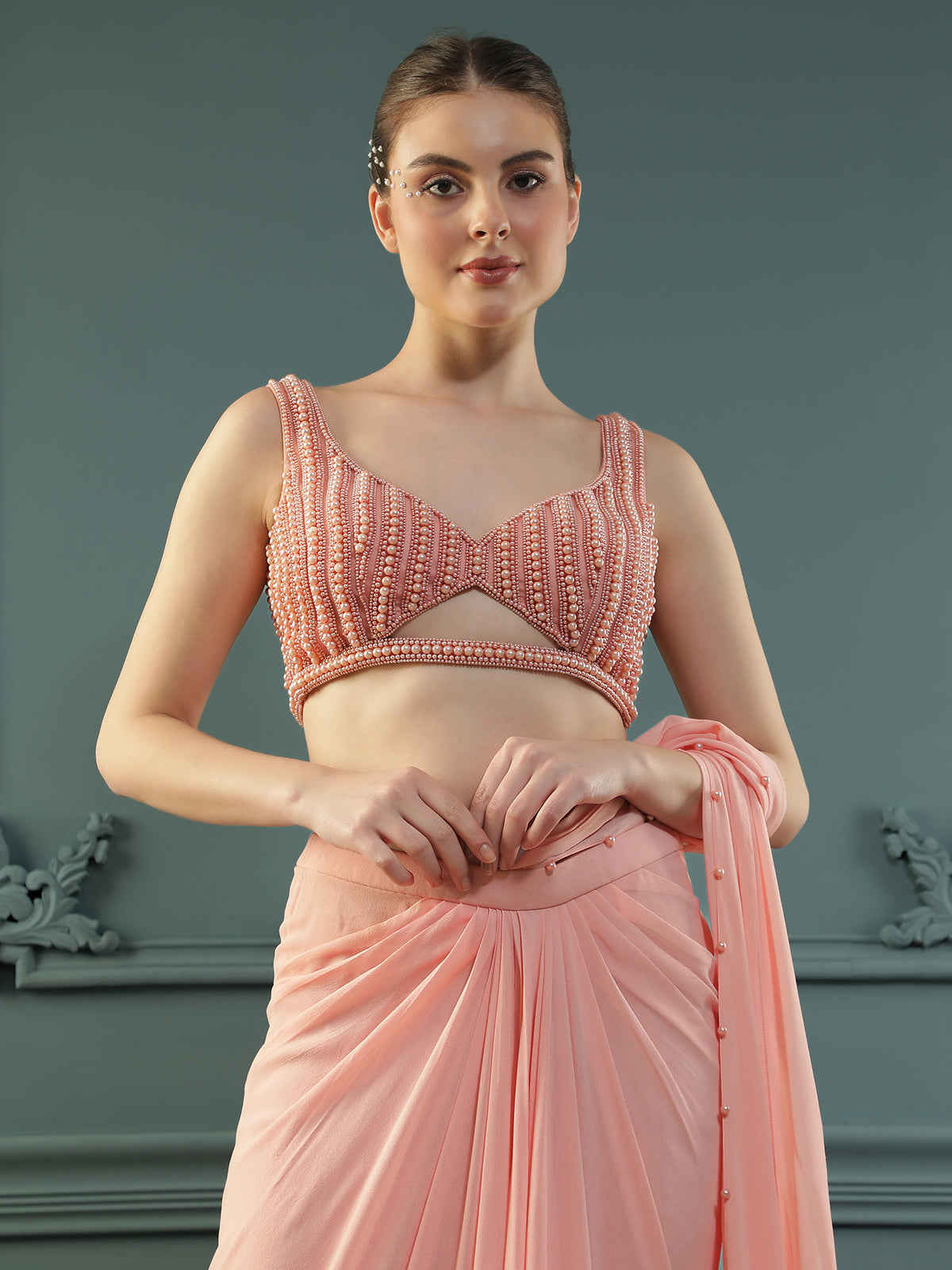 Peach pre-drape georgette saree paired beautifully with a hand-embellished pearl blouse.