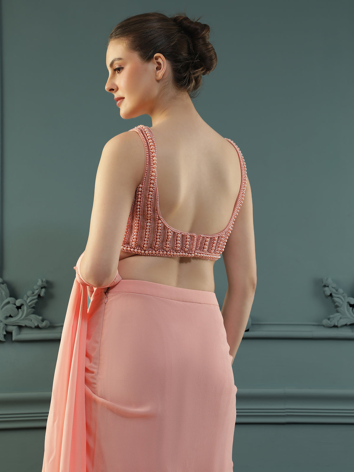 Peach pre-drape georgette saree paired beautifully with a hand-embellished pearl blouse.