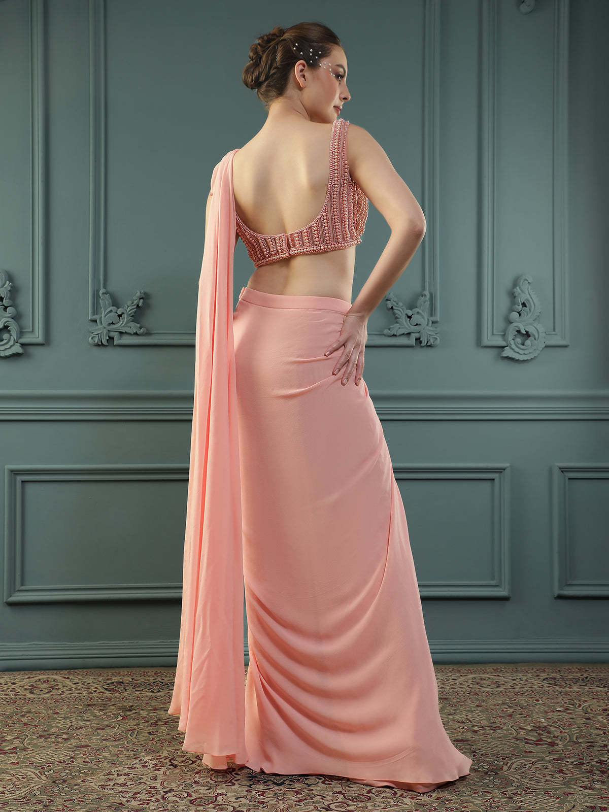 Peach pre-drape georgette saree paired beautifully with a hand-embellished pearl blouse.