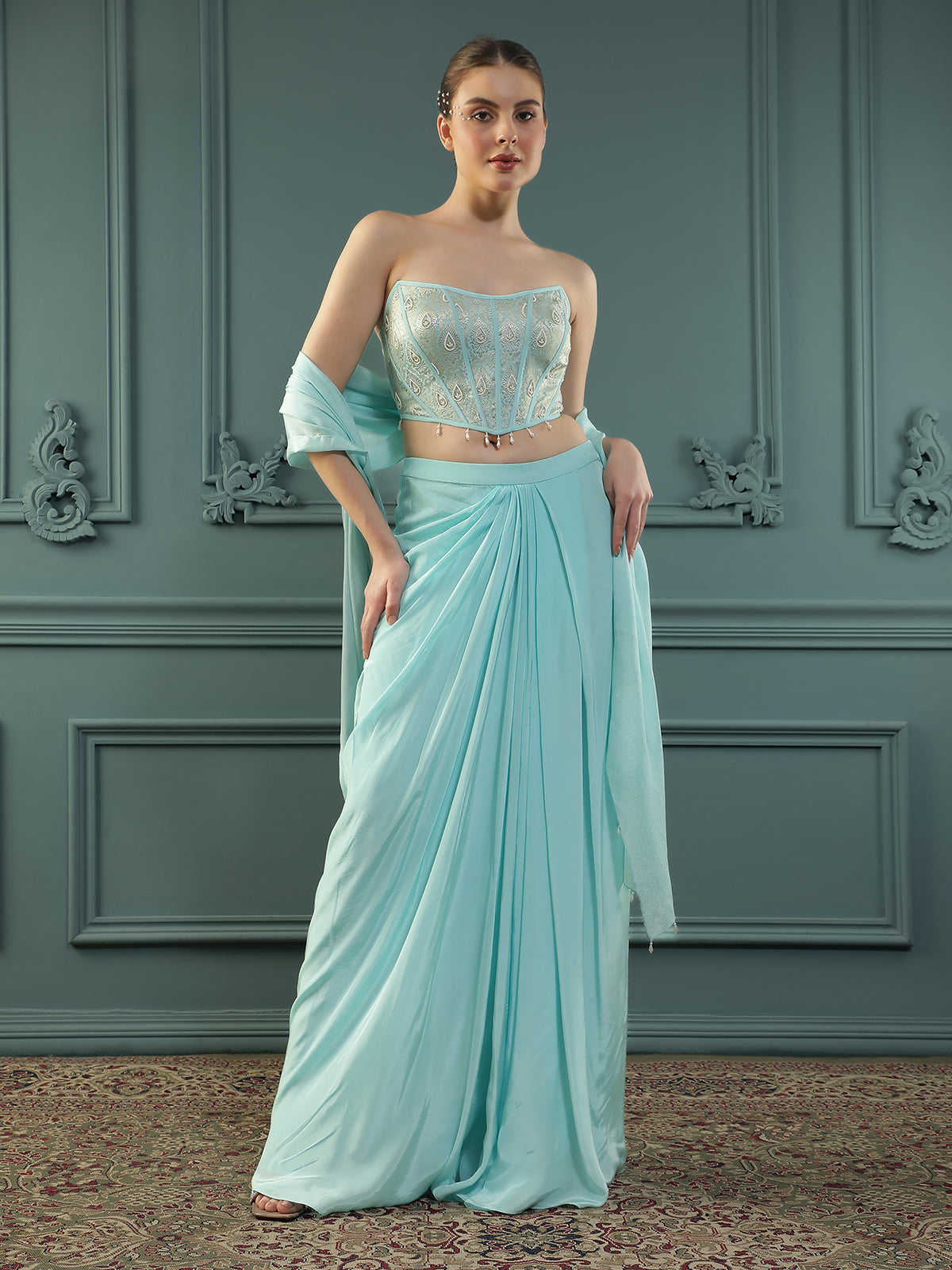 Ice-Blue drape skirt paired with brocade corset with a hand-embellished pearl highlight and plain dupatta with latkans drop on its sides.