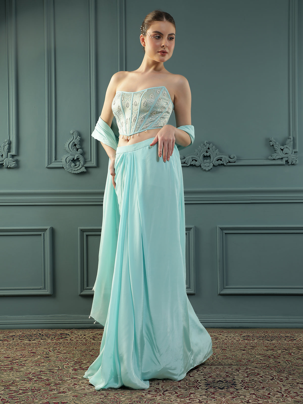 Ice-Blue drape skirt paired with brocade corset with a hand-embellished pearl highlight and plain dupatta with latkans drop on its sides.
